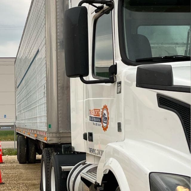 True North Truck Training cab door logo on a white tractor hitched to a silver trailer
