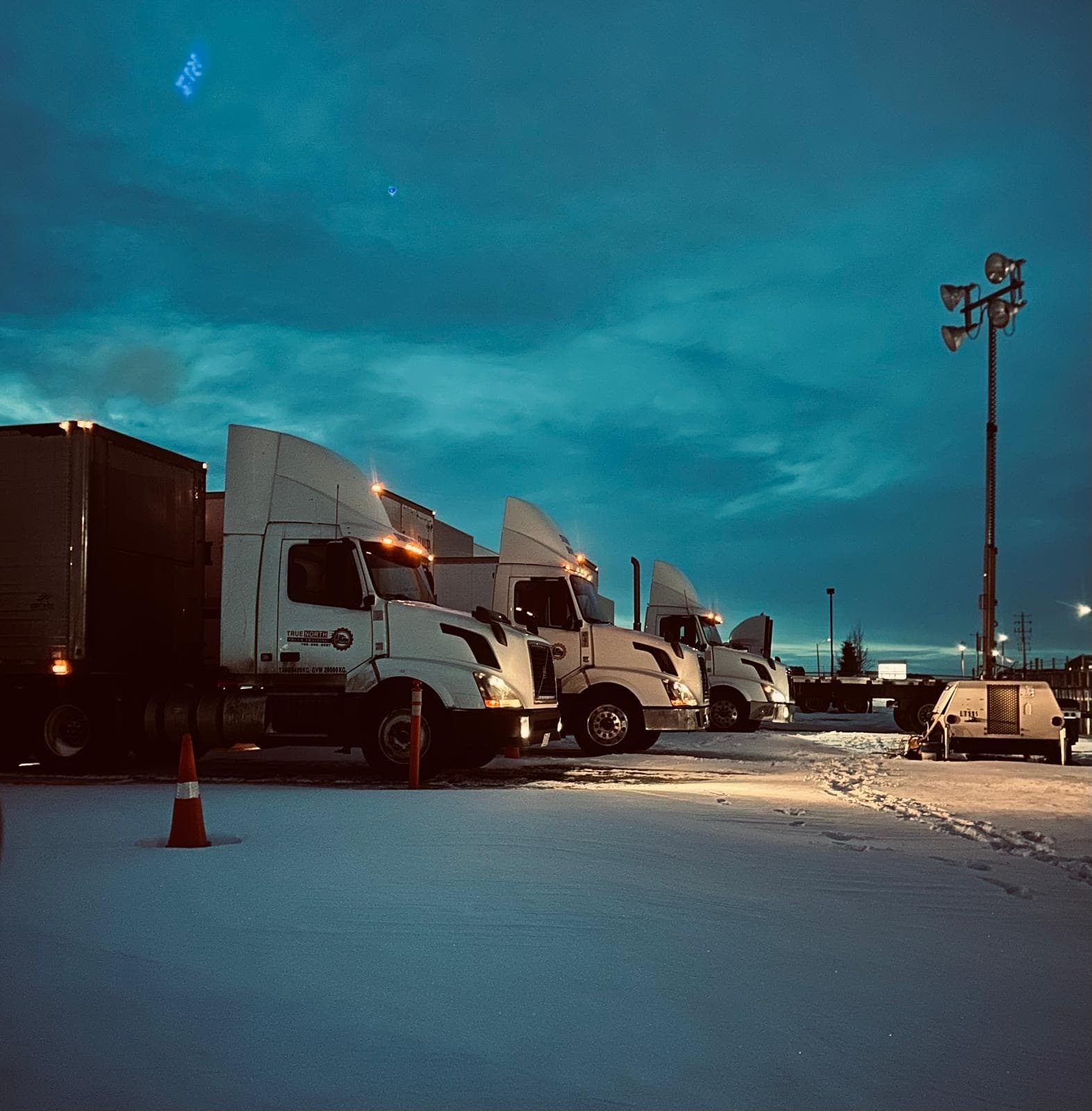 True North Truck Training fleet parked in a snow-covered lot at night